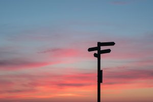 Sunset with road signs symbolising a decision